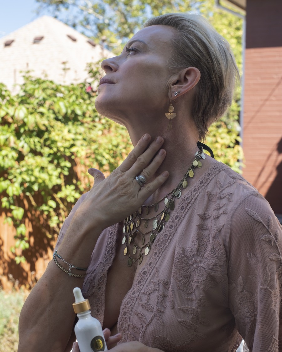 Gretchen smoothing Kissed by G botanical face oil onto her neck